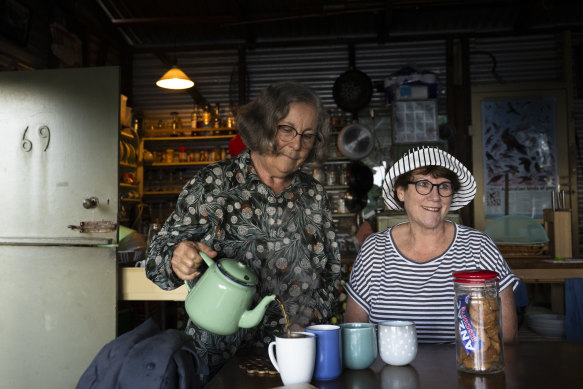 Helen Voysey in her shack at Era, pouring tea for Burning Palms shack owner Jocelyn Jones.