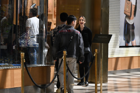 People line up as they wait to get in the Louis Vuitton shop on