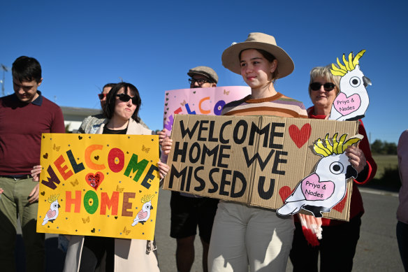 Supporters of the Nadesalingam family hold welcome signs ahead of their return to Biloela in June 2022.