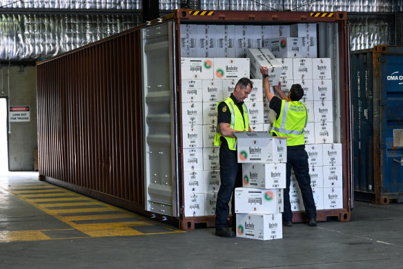 Border Force officers inspect illegal cigarettes in a shipping container in Melbourne.