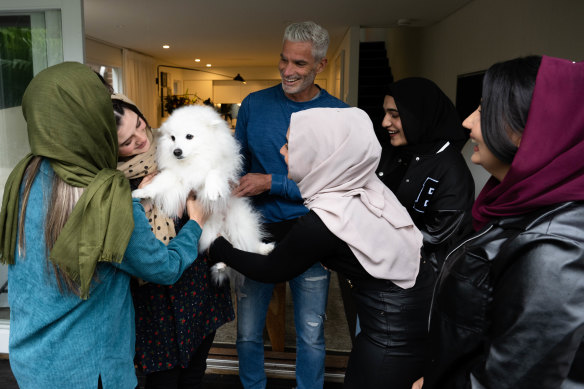 Craig Foster at home in Sydney with five young Afghan women who have become friends of the family. From left: Sahila, Frishta, Foster, Hosna, Lida and Madina.
