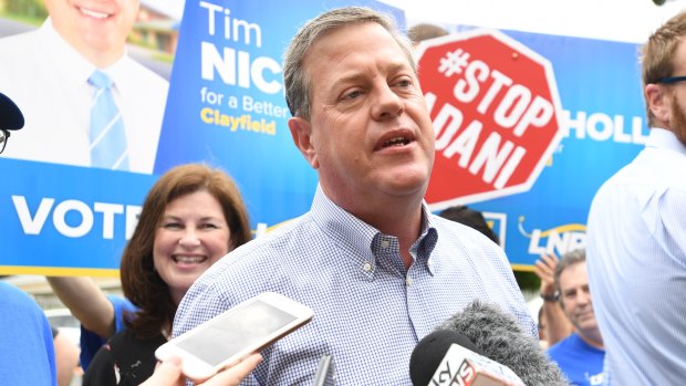 Opposition Leader Tim Nicholls is surrounded by anti-Adani protestors as he arrives to vote in his electorate of Clayfield on Saturday.