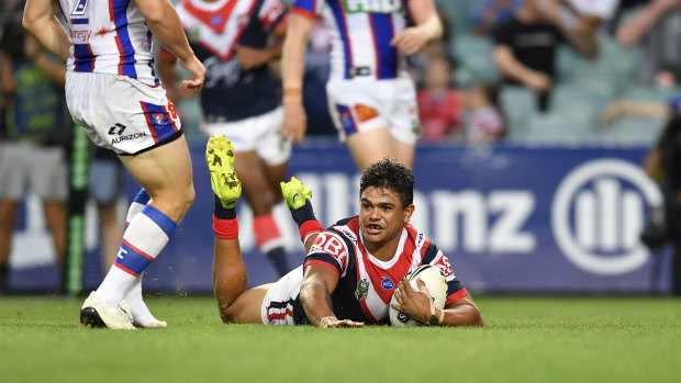 Singing in the rain: Latrell MItchell goes over for the Roosters.