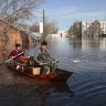 Two men ride a boat delivering food in Orenburg, Russia. Russian officials are scrambling to help homeowners displaced by the rising waters of the Ural River. 