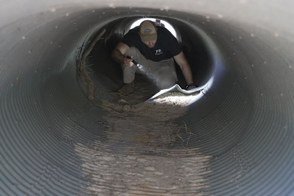 An investigator looks inside a culvert in the neighbourhood where Annie Guthrie, whose mother Nancy Guthrie has been missing for more than a week, lives just outside Tucson, Arizona.