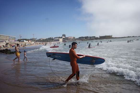 Surf Church’s pastor, the Rev. Samuel Cianelli, walks into the Atlantic Ocean to surf with his congregation in Matosinhos beach in the suburbs of Porto, Portugal.