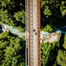Cyclists pass over a bridge in the mountainous countryside near Tarvisio where the borders of three nations converge.