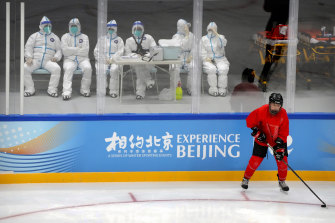 Medical personnel in protective suits watch the China Ice Sports College hockey team practise on Wednesday in a test event for the 2022 Beijing Winter Olympics.