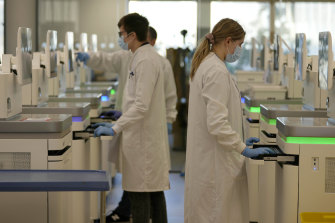 Research assistants analyse the genetic material of COVID-19 cases
on sequencing machines in Cambridgeshire, England.