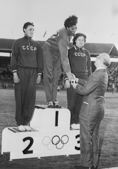 Československá reprezentantka Olga Vikotová (uprostřed) přebírá zlatou olympijskou medaili po vítězství v hodu diskem žen v Melbourne.