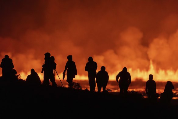 Tourists and visitors try to get a view of the eruption from a distance.