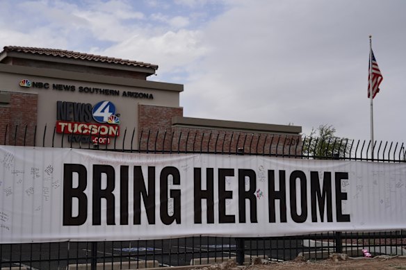 A banner on a fence outside the KVOA news station in Tucson urges action.