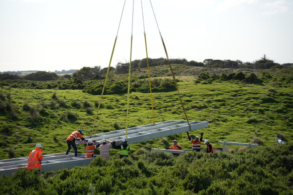 The new boardwalk is being lowered into place by helicopter piece by piece. 