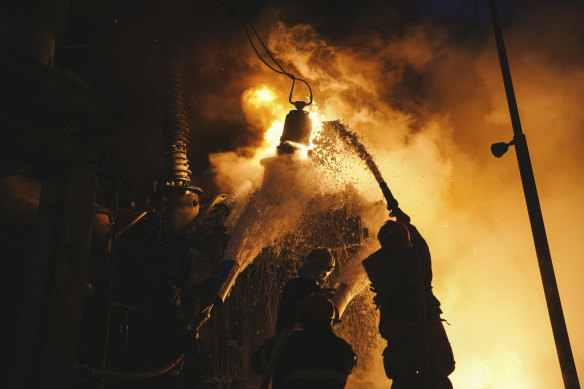 Ukrainian State Emergency Service firefighters work to extinguish a fire at an infrastructure facility after a Russian drone attack in Kyiv.