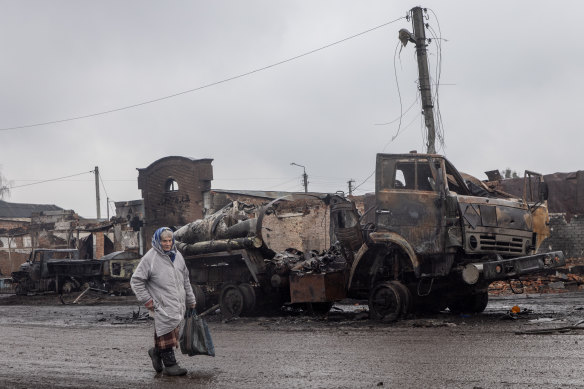 A woman walks past destroyed Russian military vehicles close to the central train station that was used as a Russian base on March 30, 2022 in Trostyanets, Ukraine.