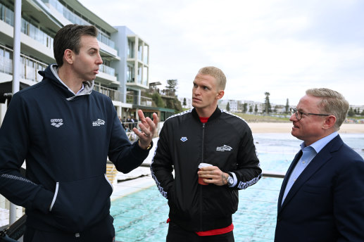 Australian Team Captain Grant Hackett (left) and swimmer Cody Simpson (centre) chat with NSW Minister for Tourism Ben Franklin (right) during the launch of the Duel in the Pool yesterday at Bondi Beach.