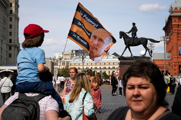 A pro-Kremlin activist holds a flag with an image of Russian President Vladimir Putting near the Kremlin.
