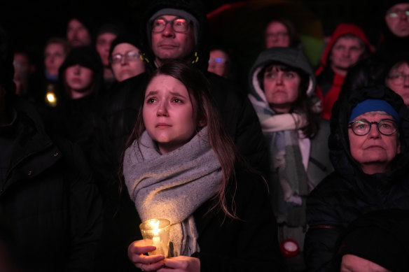 People outside Magdeburg Cathedral follow a memorial service for victims of Friday’s Christmas Market attack, where a car drove into a crowd, in Magdeburg, Germany.