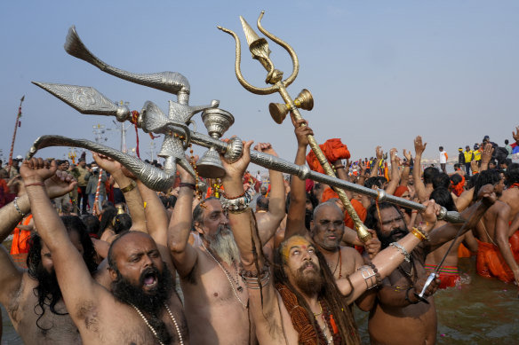 Naga Sadhus or naked Hindu holy men, react as they take a holy dip in the Sangam.