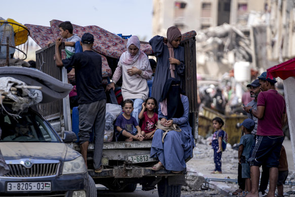 Palestinians displaced by the Israeli air and ground offensive on the Gaza Strip flee from Hamad City.