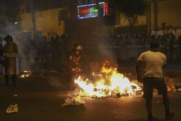 Police clear a street during anti-government protests in Lima, Peru on Friday.