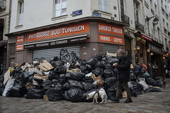 Piles of garbage cover a street corner in Paris.