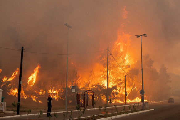 An out-of-control fire burns in the village of Hasia near Athens on Tuesday.