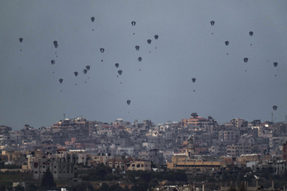 Parachutes drop supplies into the northern Gaza Strip, as seen from southern Israel.