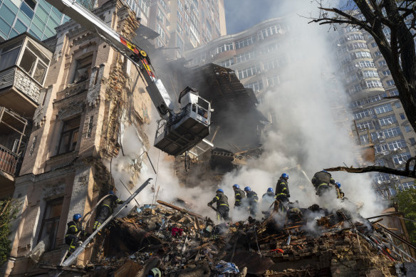 Firefighters work after a drone attack on buildings in Kyiv on Monday.