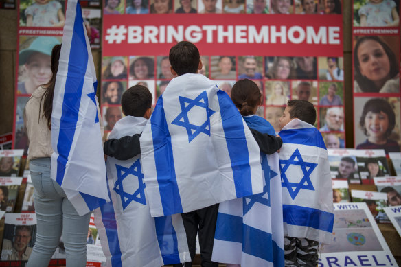 I bambini guardano le foto degli israeliani rapiti durante una marcia a cui si sono uniti centinaia di persone in solidarietà con Israele e gli ostaggi tenuti a Gaza, a Bucarest, in Romania.