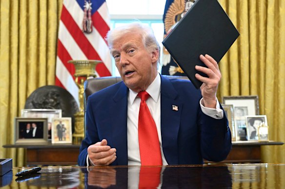 Trump holding an executive order in the Oval Office on Wednesday.