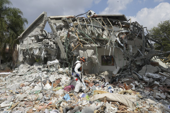 An Israeli soldier walks past a house destroyed by Hamas militants in Be’eri kibbutz, Israel.