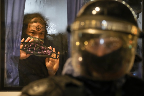 A detained demonstrator shows a ‘No War!’ sign from a police bus in St. Petersburg, Russia.