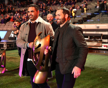 Greg Inglis and Dallas Johnson carry out a replica of the 2009 premiership trophy that the NRL stripped from the Storm.