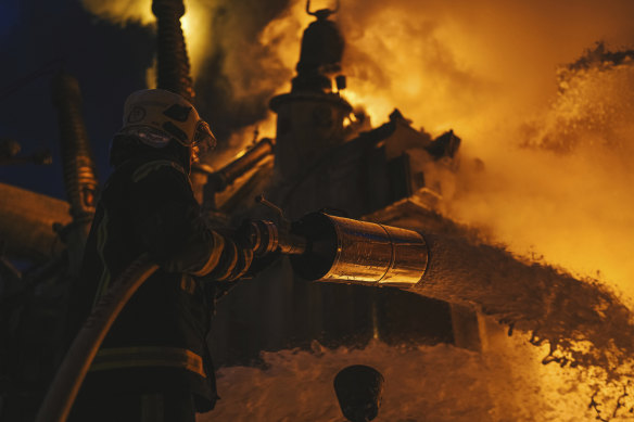 Ukrainian State Emergency Service firefighters work to extinguish a fire at an infrastructure facility after a Russian drone attack in Kyiv in mid-December.