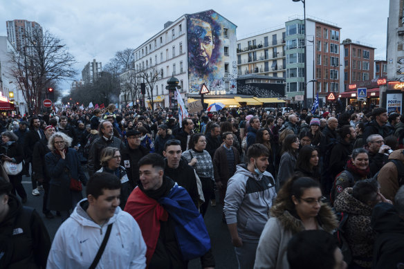 İnsanlar Cumartesi günü Paris'te bir protesto sırasında yürüyor.  Başkan Macron'un tartışmalı emeklilik reformuna karşı hafta sonu Fransa'da bir dizi protestonun devam etmesi planlandı.