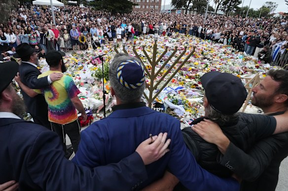 Mourners gather at Bondi Pavilion’s floral memorial at for victims of the massacre on Sunday.