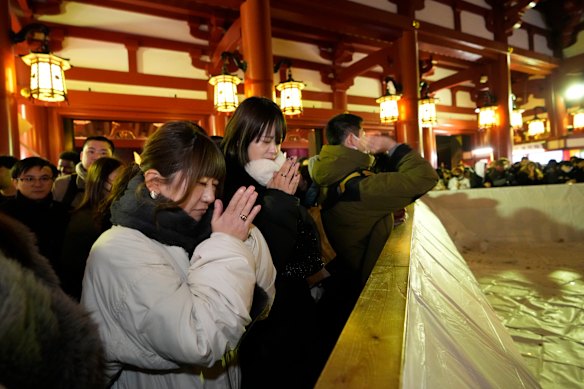 People praying on their traditional New Year’s pilgrimage at the main hall of Sensoji Buddhist temple in Tokyo.