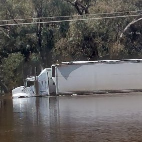 A truck pulling a semi-trailer through floodwaters outside Rochester on Monday.