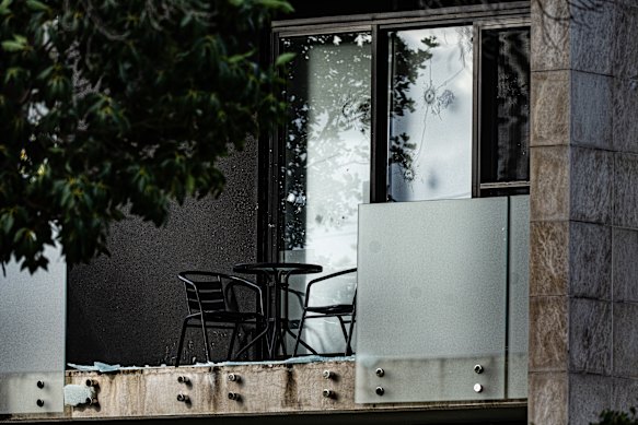 Bullet holes and shattered glass on the second-storey balcony of the home.