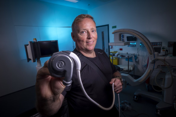 Patient Peter Callinan holding the latest heart pump on the market, one of which keeps him alive as he waits on the transplant list. But the new artificial heart could mean he never needs a transplant.