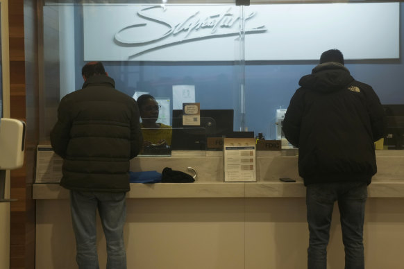 Customers do business at a branch of Signature Bank in New York on Monday.