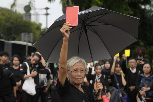 Maria Catarina Sumarsih, whose son was killed by security forces in 1998, holds up a red card as a warning for President Joko Widodo, who backed Prabowo Subianto.