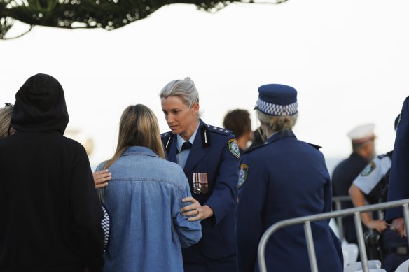 Police officer Amy Scott comforts mourners at Bondi Beach.
