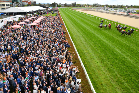 Crowds enjoy the action at the Caulfield Cup at Caulfield Racecourse. 