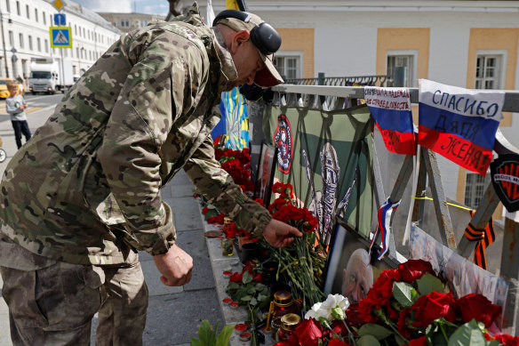 A man lays flowers at a makeshift memorial in Moscow set up after the presumed death of Yevgeny Prigozhin.
