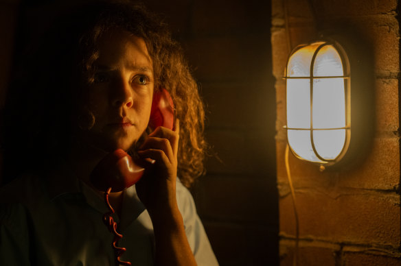 Felix Cameron as Eli Bell answers the mysterious red phone in Boy Swallows Universe.