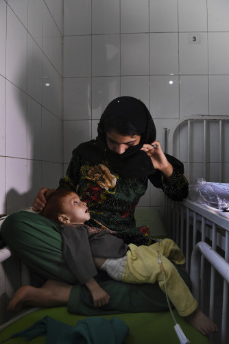 Saber, 10 months old and suffering from severe acute malnutrition is comforted by his mother Shahr Banoo, 15.