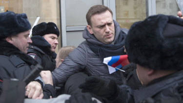 Russian opposition leader Alexei Navalny, centre, is detained by police officers in Moscow on Sunday. , 