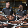 Sports Heads owners, Jake Fenech and Enzo Montana with some of the large heads of players that fans have been buying ahead of the weekend’s NRL Grand Final. 